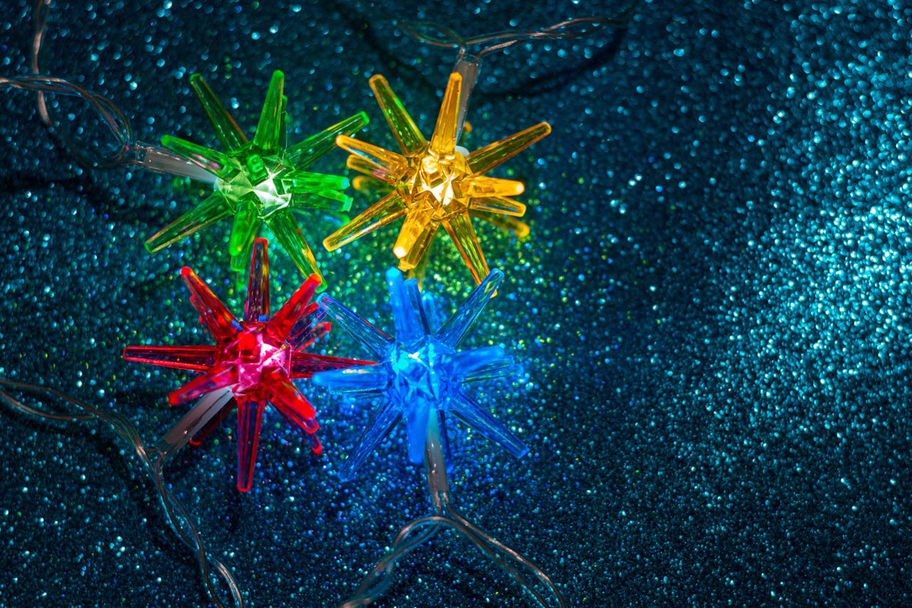 Vibrant star-shaped string lights creating a festive ambiance on a glitter background.